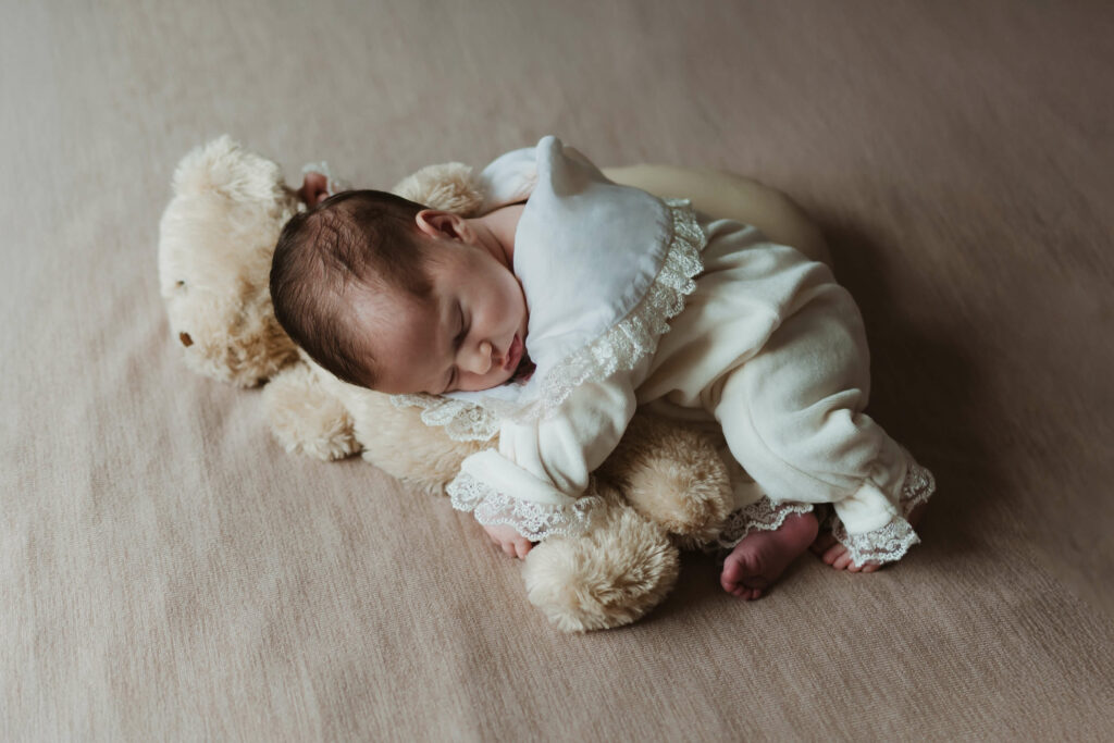 Lifestyle fotografisanje beba dok beba spava na bračnom krevetu u svom domu.