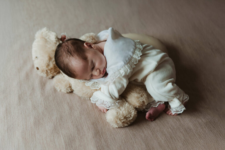 Lifestyle fotografisanje beba dok beba spava na bračnom krevetu u svom domu.