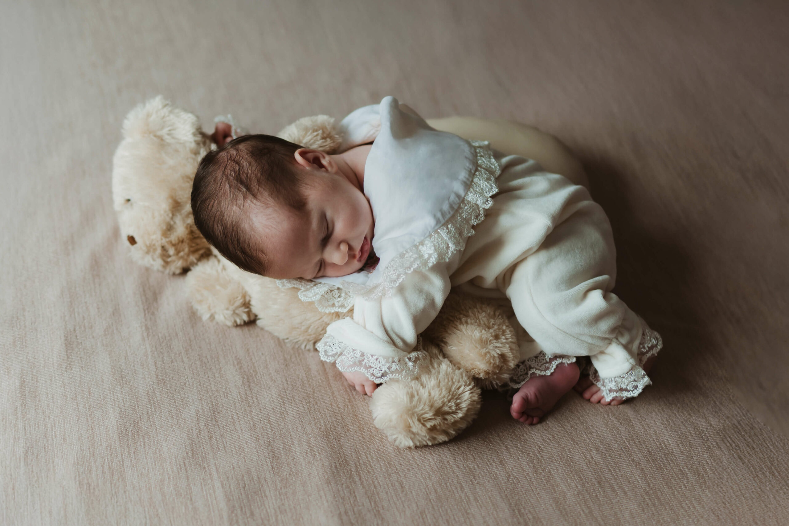 Lifestyle fotografisanje beba dok beba spava na bračnom krevetu u svom domu.